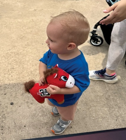 A child holding the red Pouty Pony plush toy