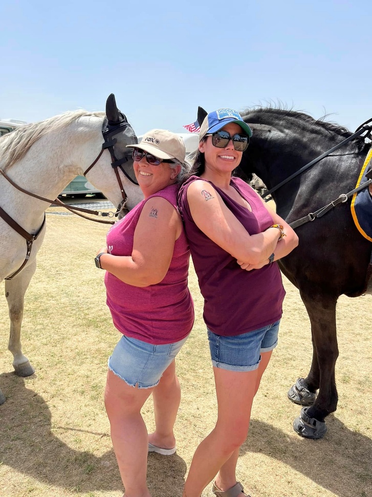 Festival fans wearing playful horse masks beside an A&O patrol horse